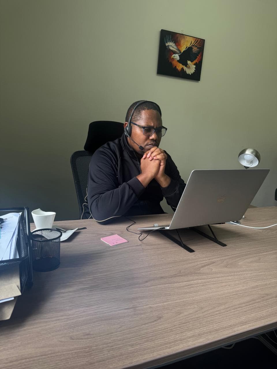 Sikika team member on a headset call at a workstation